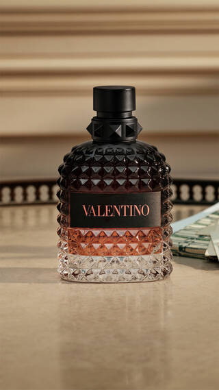 Bottle of BORN IN ROMA Uomo Coral Fantasy on tan granite table