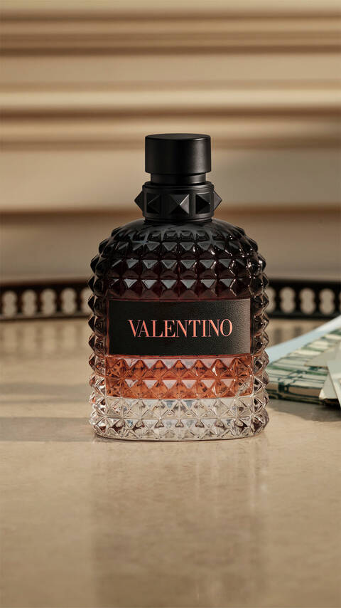 Bottle of BORN IN ROMA Uomo Coral Fantasy on tan granite table