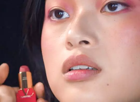 Close-up of woman with pink and orange eye makeup
