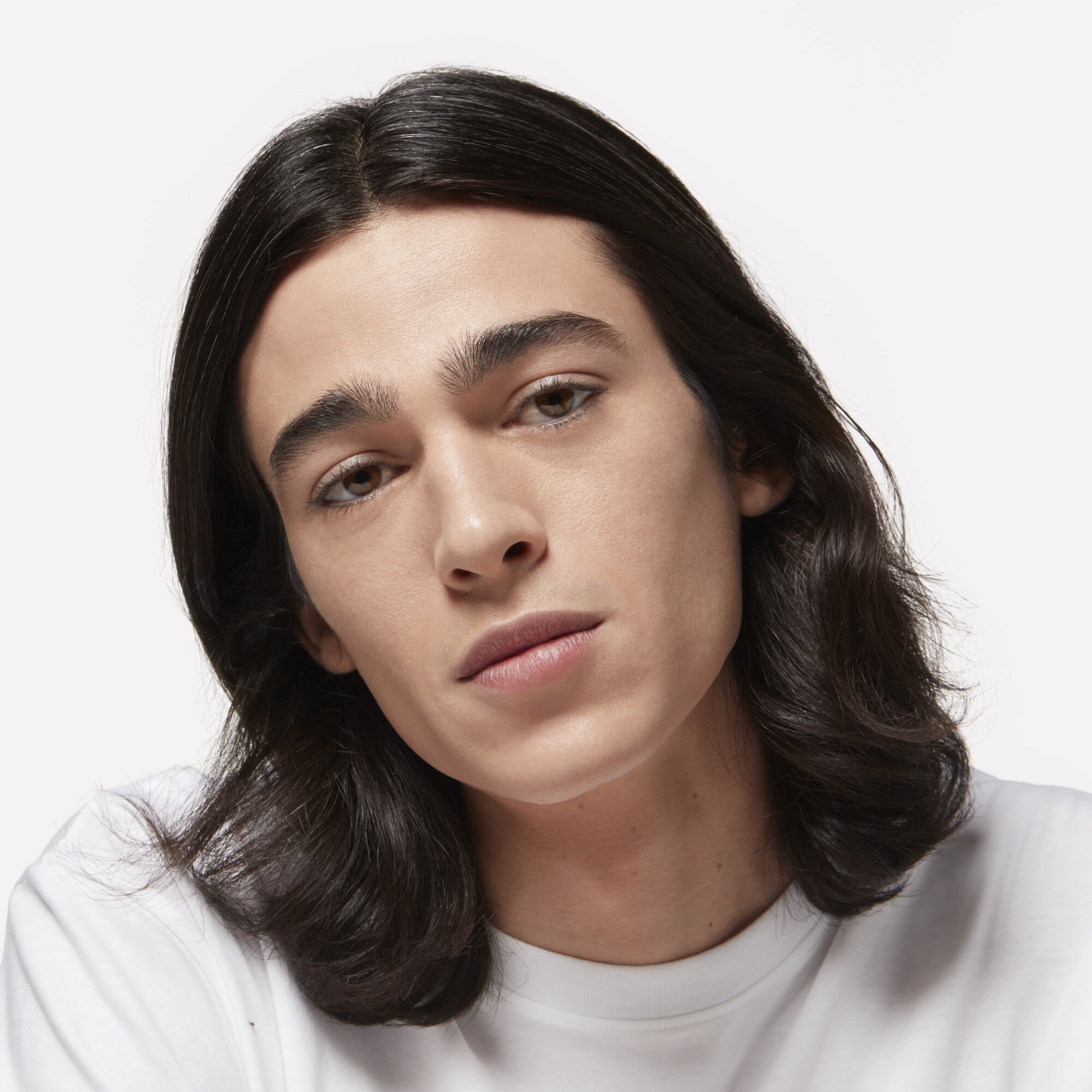 Man with long black hair and full eyebrows