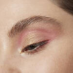 Close-up of an eye with pink and gold eye makeup