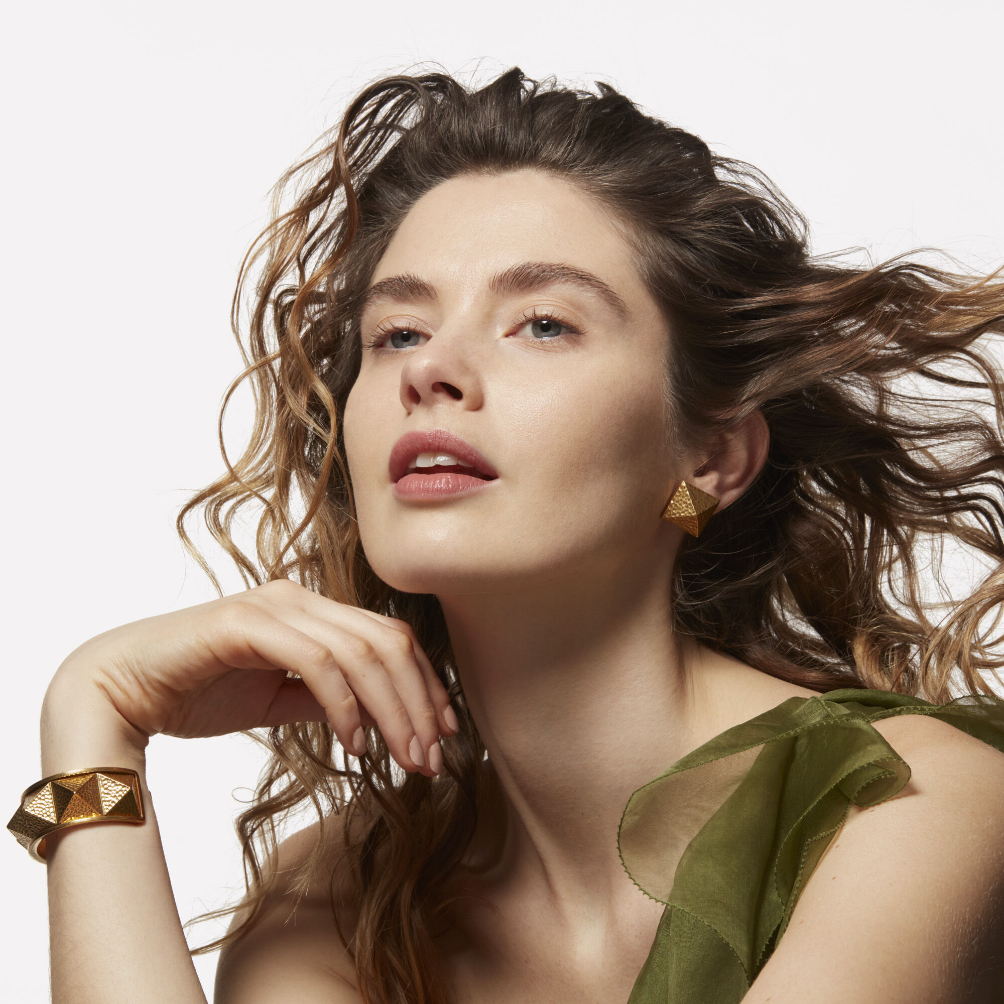 A model with light brown wavy hair flowing behind her