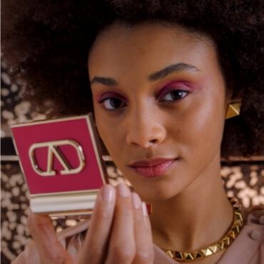 A woman with pink eyeshadow holding the Eye2Cheek Blush and Eyeshadow compact