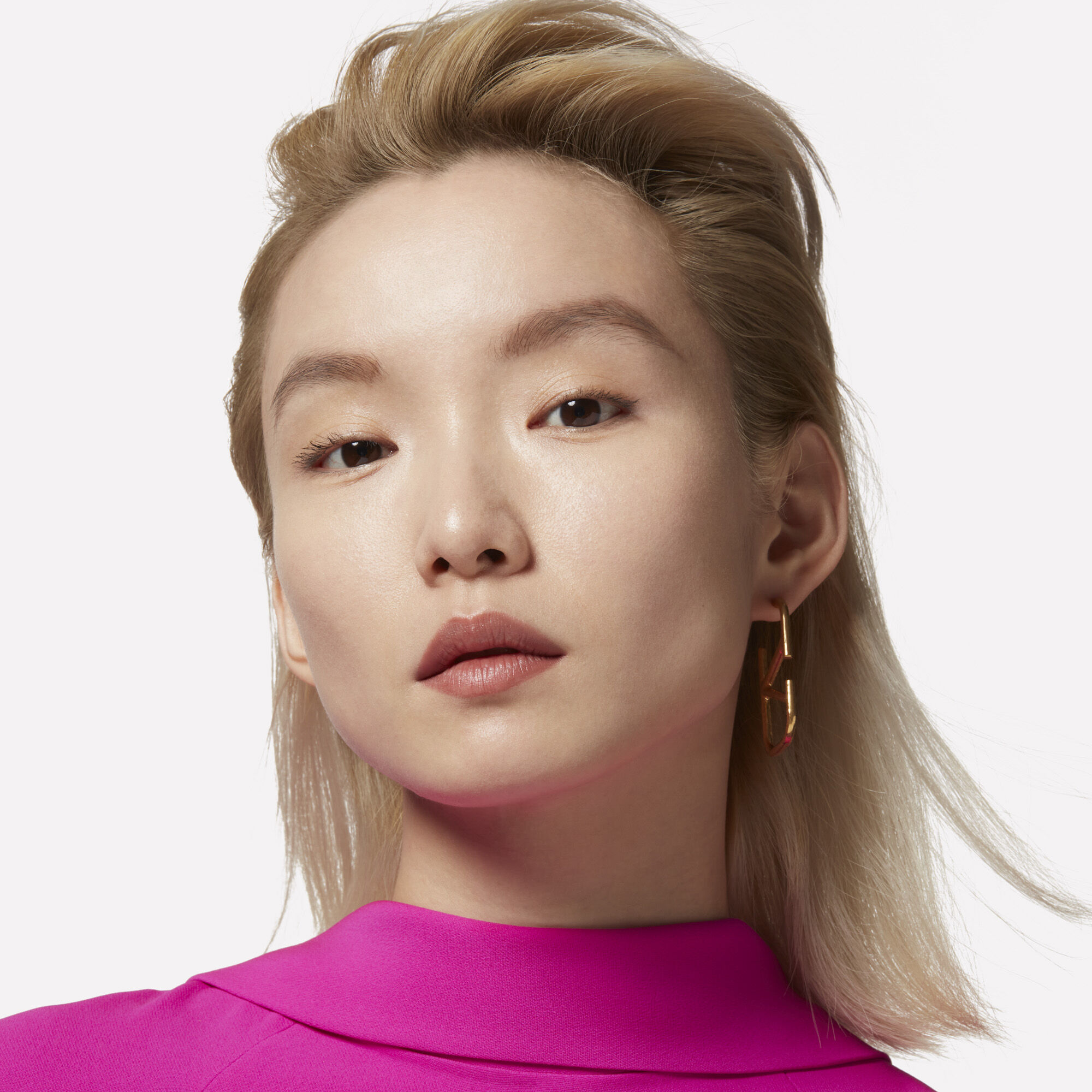 A model with slicked-back platinum-blonde hair