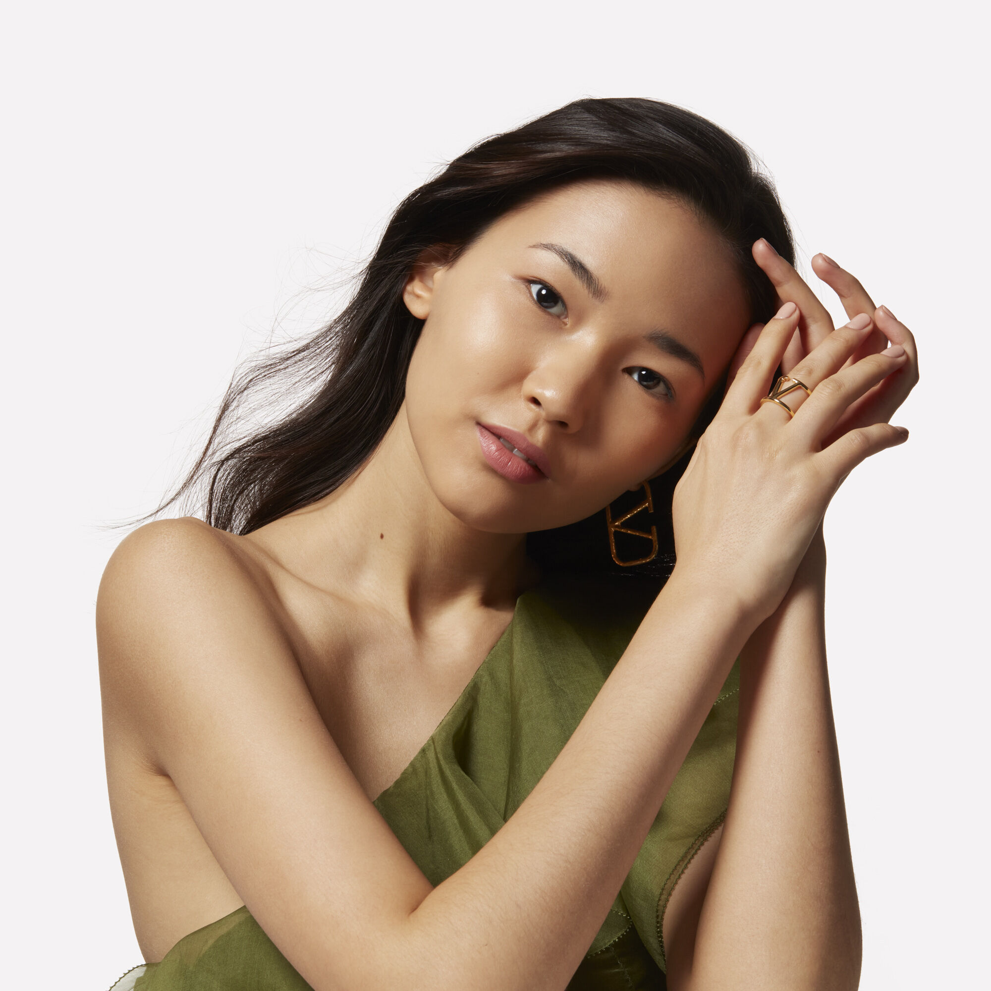 A model with long dark brown hair tilting her head to the side
