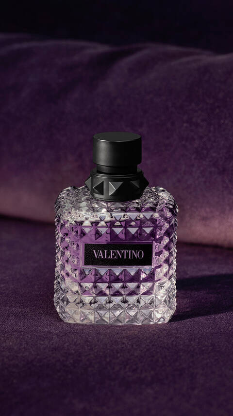Bottle of BORN IN ROMA Purple Melancholia on purple velvet background