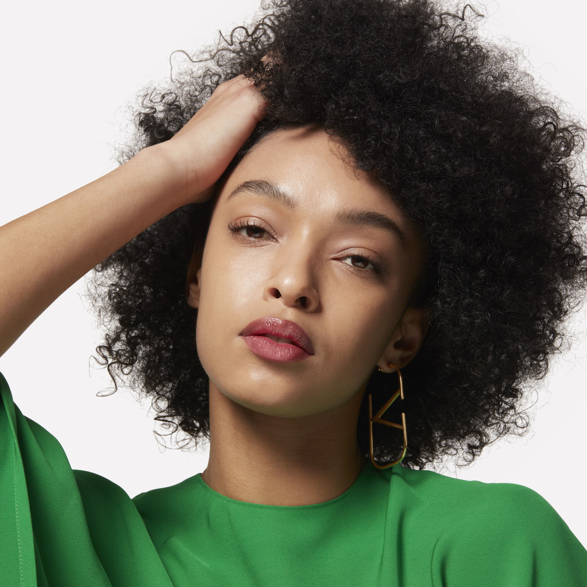 A model with fingers in her short curly afro